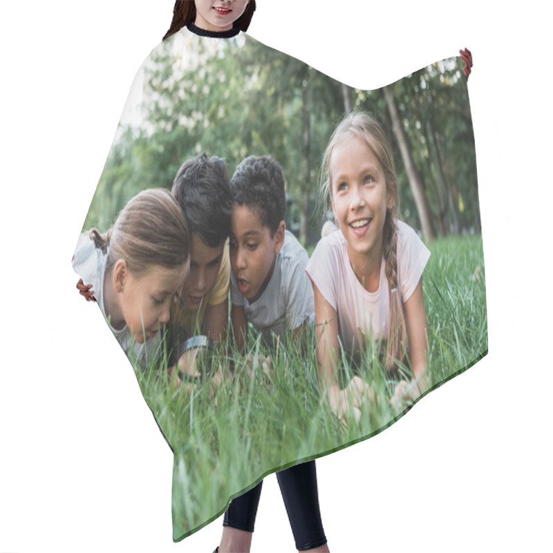 Personality  Selective Focus Of Cute Multicultural Children Looking At Green Grass Though Magnifier  Hair Cutting Cape