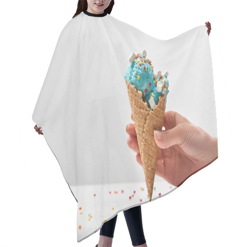 Personality  Cropped View Of Woman Holding Delicious Sweet Blue Ice Cream With Marshmallows And Sprinkles In Crispy Waffle Cone Isolated On Grey Hair Cutting Cape