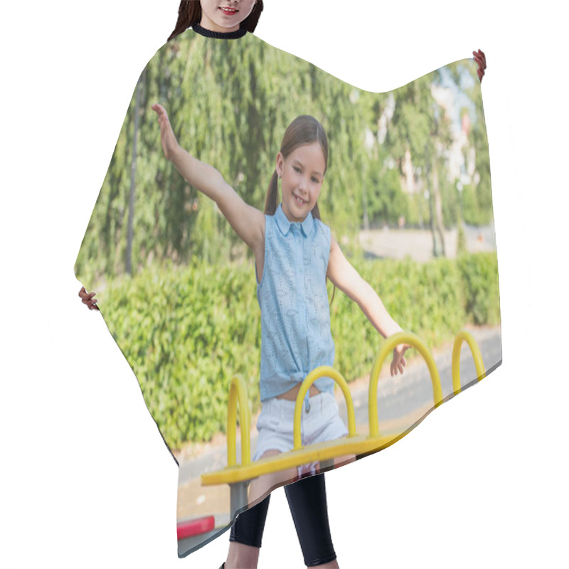 Personality  Excited Girl Looking At Camera While Riding Seesaw With Outstretched Hands Hair Cutting Cape