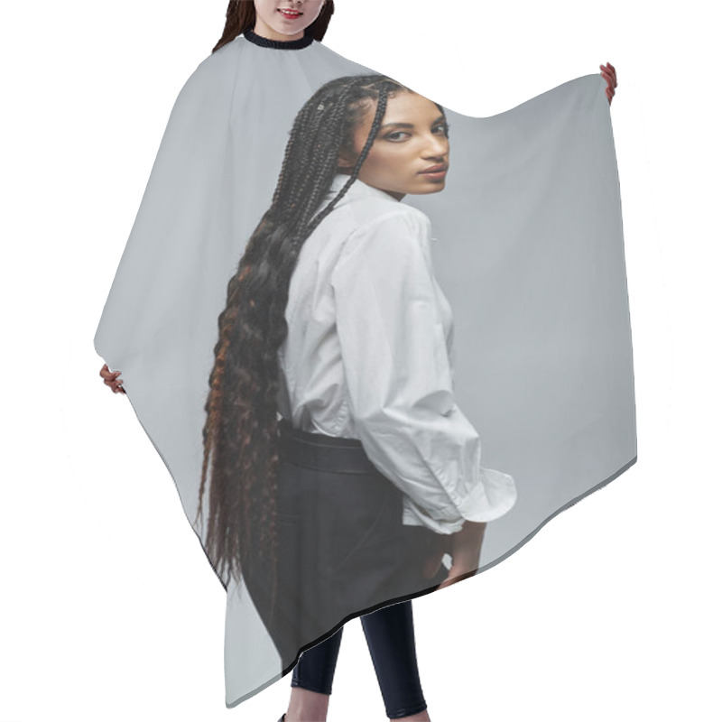 Personality  A Stylish Young Woman With Long Braids Poses In A Crisp White Shirt Against A Gray Backdrop. Hair Cutting Cape