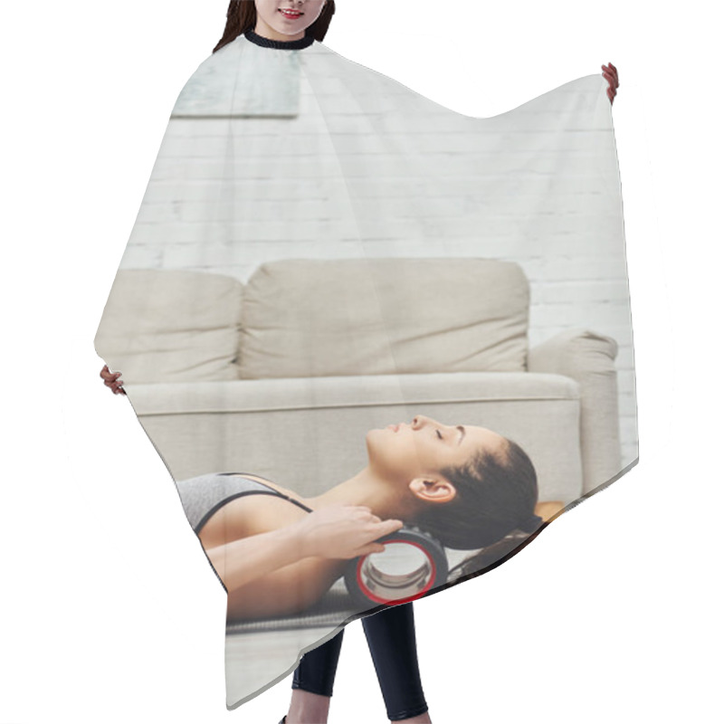 Personality  Side View Of Young Brunette Woman In Activewear Massaging Neck With Modern Roller Massager On Fitness Mat In Living Room At Home, Sense Of Tranquility And Promote Relaxation Concept Hair Cutting Cape