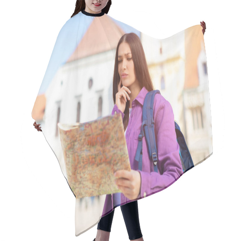 Personality  A Young Woman Tourist With A Backpack Seems Lost, Holding A Map With Historical Buildings In The Background Hair Cutting Cape