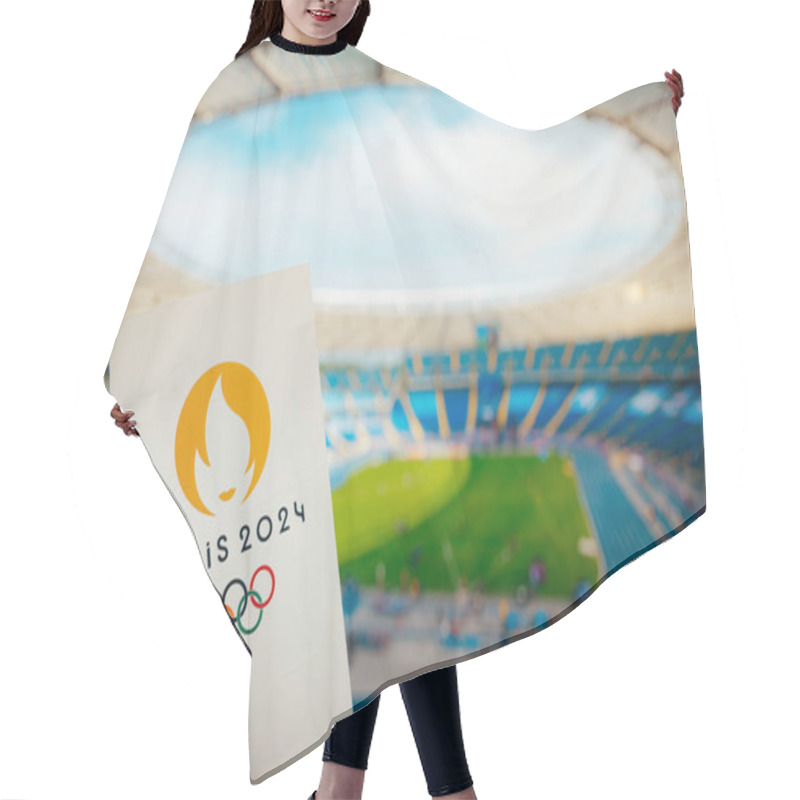 Personality  PARIS, FRANCE, JULY 7, 2023: Embracing The Symbol: Athlete Holds Iconic Emblem Of Paris 2024 Summer Olympics, With Modern Stadium As A Majestic Backdrop. A Symbolic Prelude To Paris 2024 Olympics Hair Cutting Cape