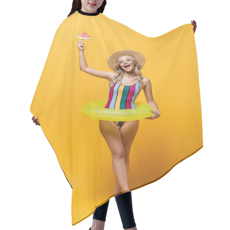 Personality  Full Length Of Amazed Woman Standing With Inflatable Ring And Holding Popsicle Stick With Watermelon On Yellow Hair Cutting Cape