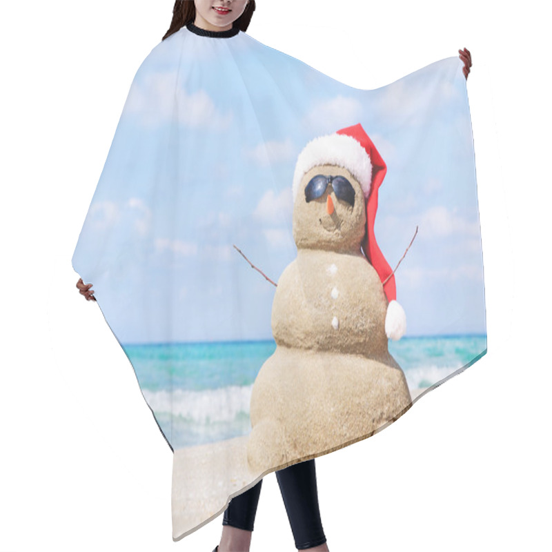 Personality  Smiling Sandy Snowman In Red Santa Hat On The Sea Beach. Hair Cutting Cape