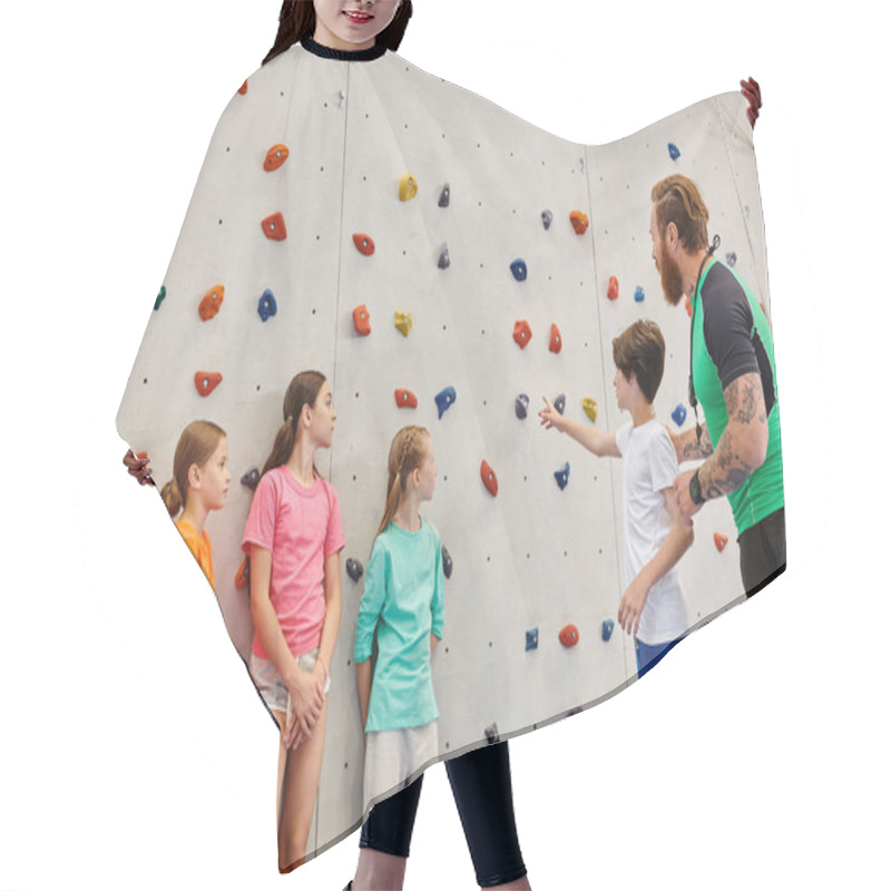 Personality  A Man Teaches A Group Of Diverse Children How To Climb On A Rock Wall In A Bright, Lively Classroom Setting. Hair Cutting Cape