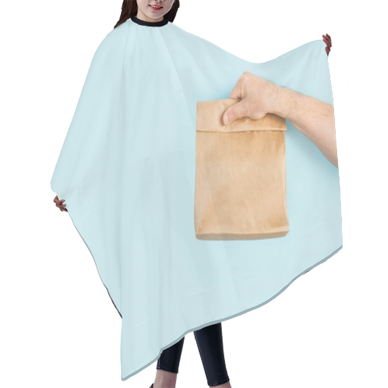 Personality  Mans Hand Holding A Brown Paper Bag On A Light Blue Background Hair Cutting Cape