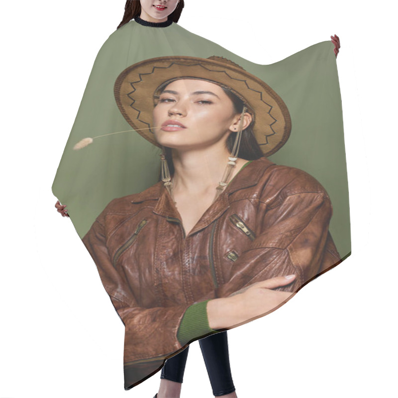 Personality  Brunette Woman Poses Stylishly In A Brown Leather Jacket And Hat Against A Green Backdrop. Hair Cutting Cape