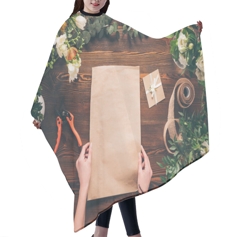 Personality  Cropped Image Of Florist Holding Empty Sheet Of Paper In Hands  Hair Cutting Cape