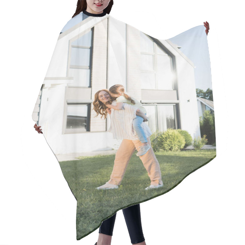 Personality  Smiling Mother Piggybacking Daughter Near Modern House Hair Cutting Cape