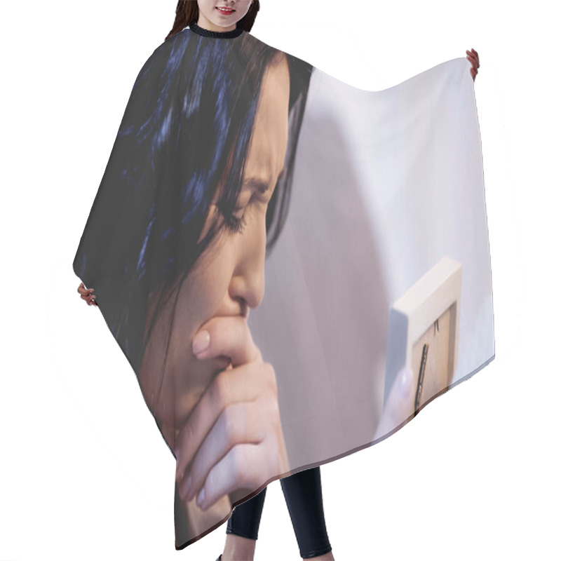 Personality  Woman Holding Photo Frame And Crying With Mouth Covered With Hand At Home Hair Cutting Cape