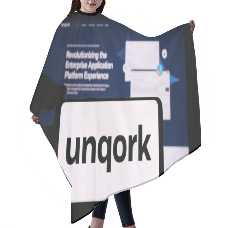 Personality  Stuttgart, Germany - 08-25-2024: Person Holding Cellphone With Logo Of American Enterprise Application Platform Company Unqork Inc. In Front Of Webpage. Focus On Phone Display. Hair Cutting Cape