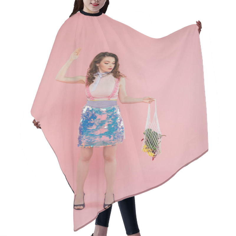 Personality  Housewife Concept, Attractive Young Woman Posing And Gesturing Like A Doll, Holding Reusable Mesh Bag With Groceries, Stylish Wife Doing Daily House Duties, Standing On Pink Background  Hair Cutting Cape