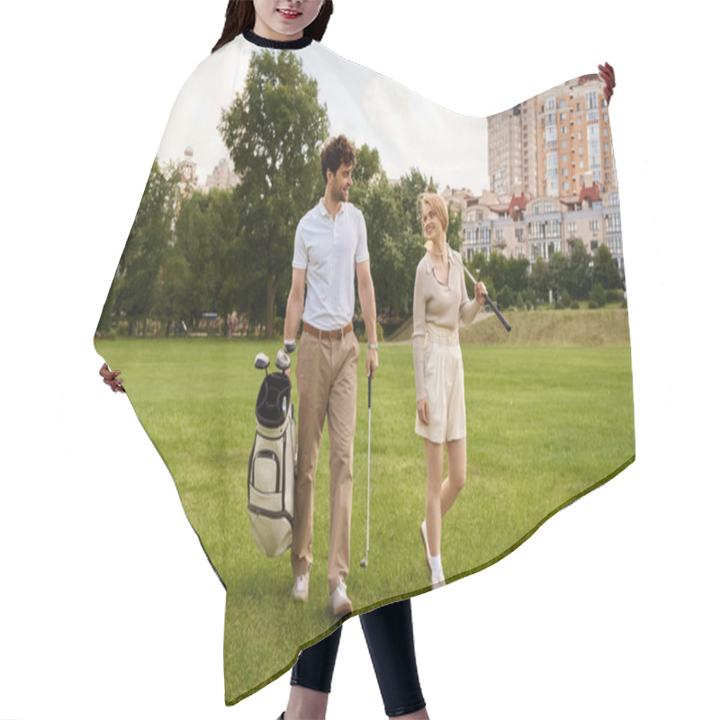 Personality  A Young Couple In Elegant Attire Leisurely Walk Across A Lush Green Golf Course, Enjoying A Luxurious Outdoor Experience Together. Hair Cutting Cape