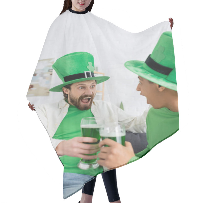 Personality  Excited Man In Green Hat Holding Beer Near African American Friend At Home  Hair Cutting Cape