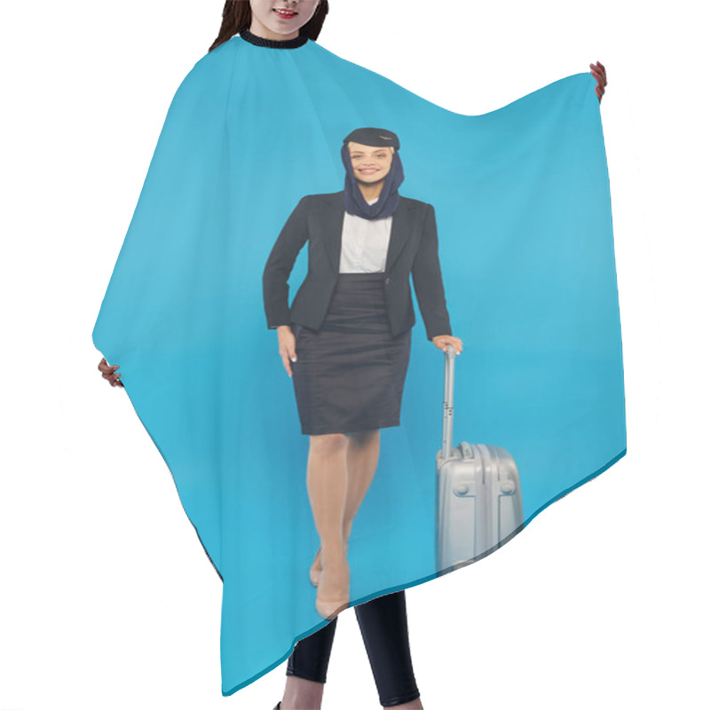 Personality  Elegant Stewardess In Uniform Of Arabian Airlines Standing With Hand On Hip And Travel Bag On Blue Hair Cutting Cape