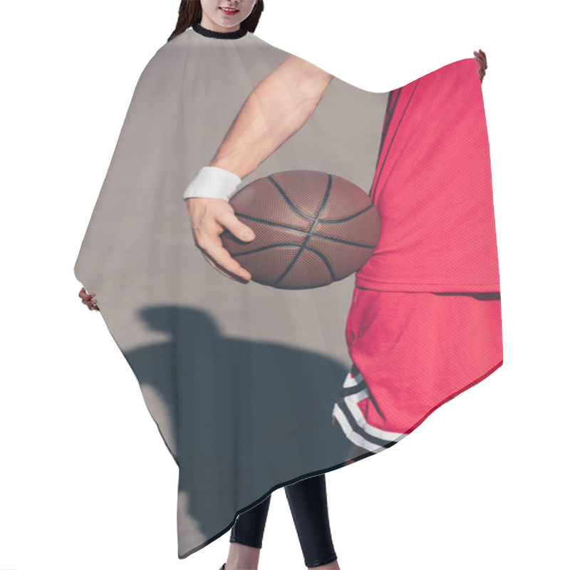 Personality  Cropped Image Of Sportsman Holding Basketball Ball On Street Hair Cutting Cape