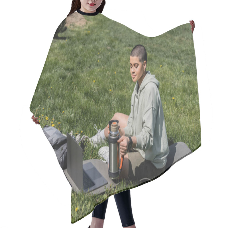 Personality  Young Short Haired Woman Tourist Holding Thermos While Sitting On Fitness Mat Near Laptop And Backpack On Grassy Lawn With Flowers, Finding Serenity In Nature, Summer, Digital Nomad  Hair Cutting Cape