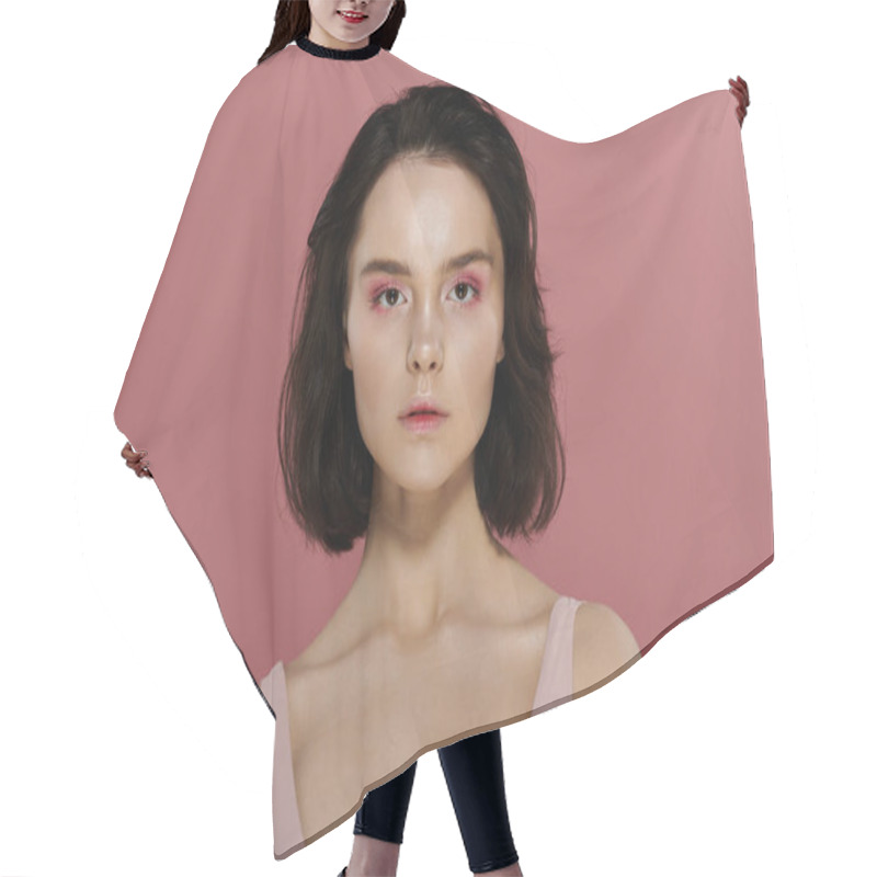 Personality  A Woman With Short Dark Hair Poses Against A Vibrant Pink Background. Hair Cutting Cape