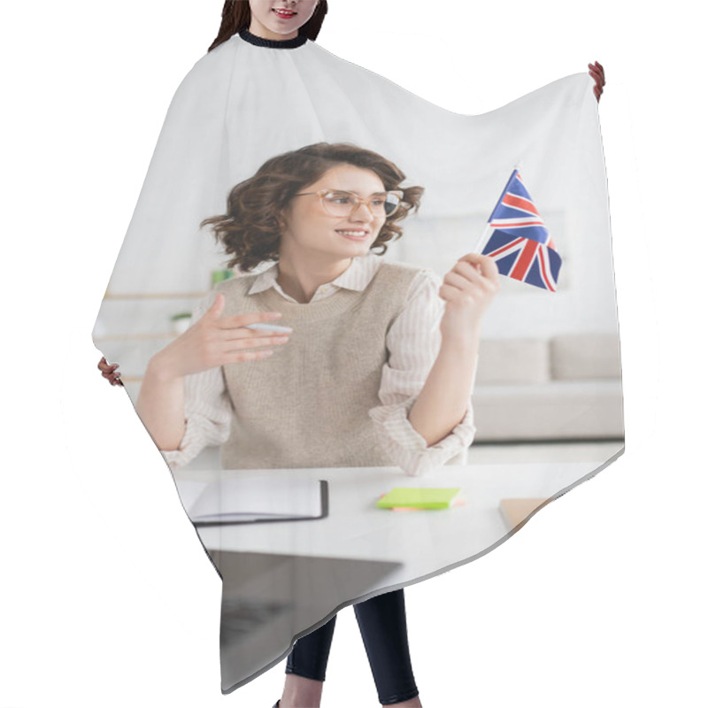 Personality  Cheerful Language Teacher Looking At Flag Of United Kingdom While Sitting Near Blurred Laptop At Home Hair Cutting Cape