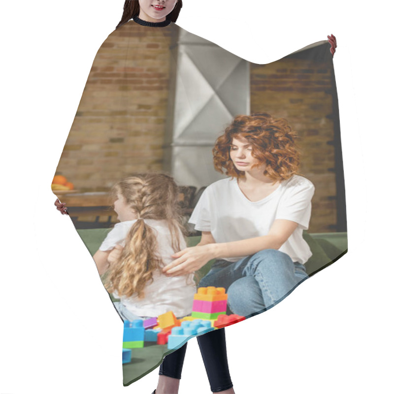 Personality  Curly Mother Looking At Offended Daughter Near Building Blocks  Hair Cutting Cape