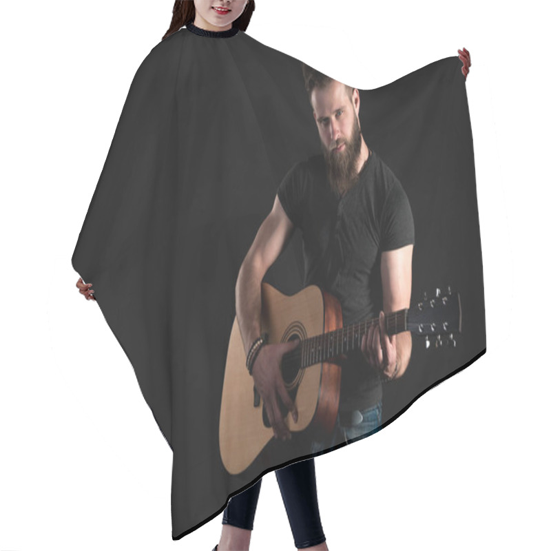 Personality  A Charismatic And Stylish Man With A Beard Stands And Plays An Acoustic Guitar On A Black Isolated Background. Horizontal Frame Hair Cutting Cape