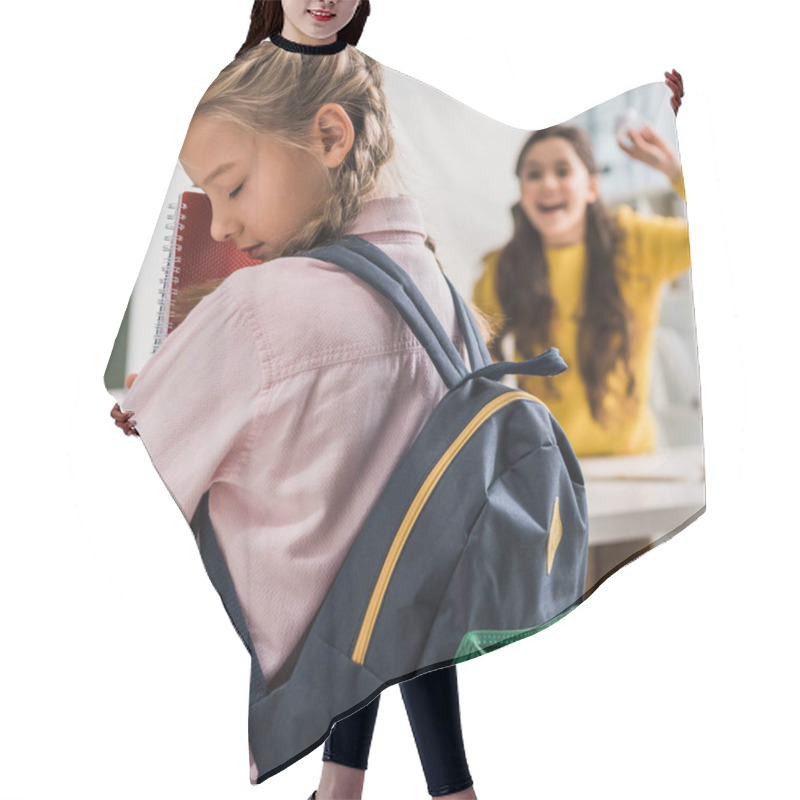 Personality  Selective Focus Of Bullied Schoolgirl With Backpack Holding Notebooks Near Cruel Schoolkid Hair Cutting Cape