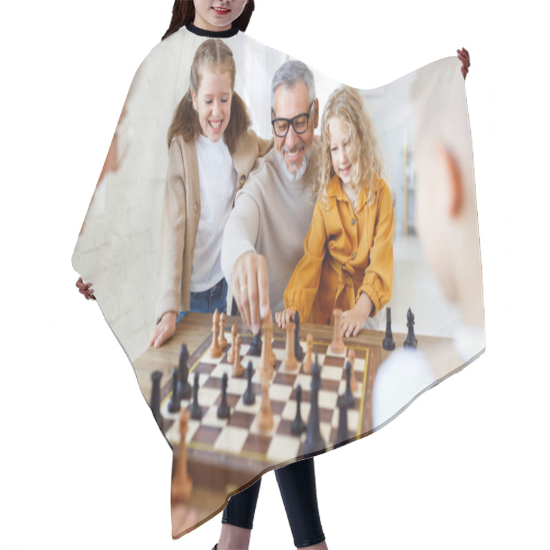 Personality  Children Brother And Sister Playing Chess While Sitting In Living Room With Senior Grandparents Hair Cutting Cape