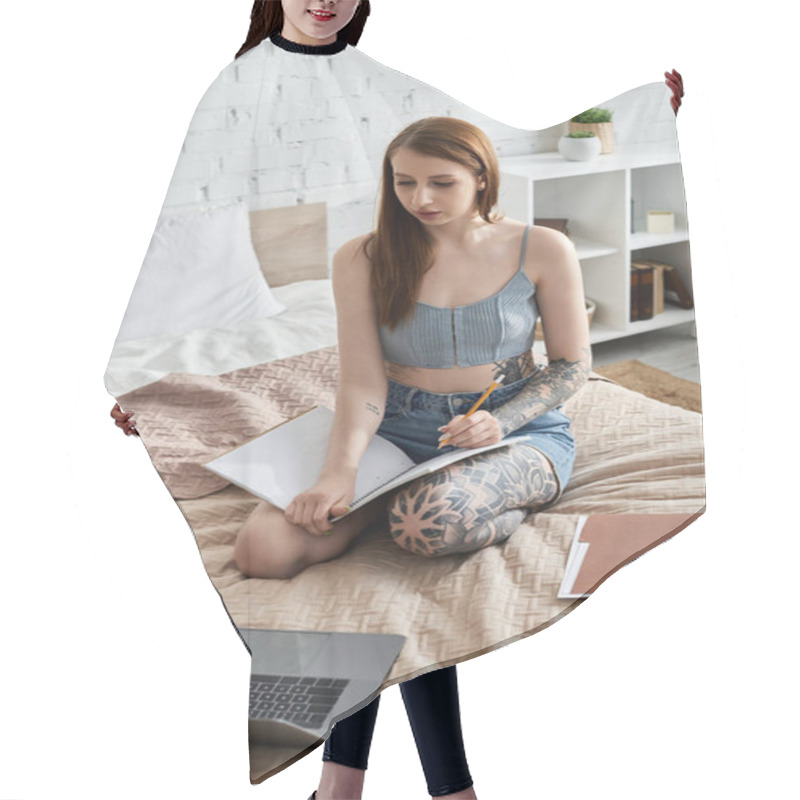 Personality  A Young Woman With Tattoos Sits On A Bed In A Modern Apartment, Writing In A Notebook. Hair Cutting Cape