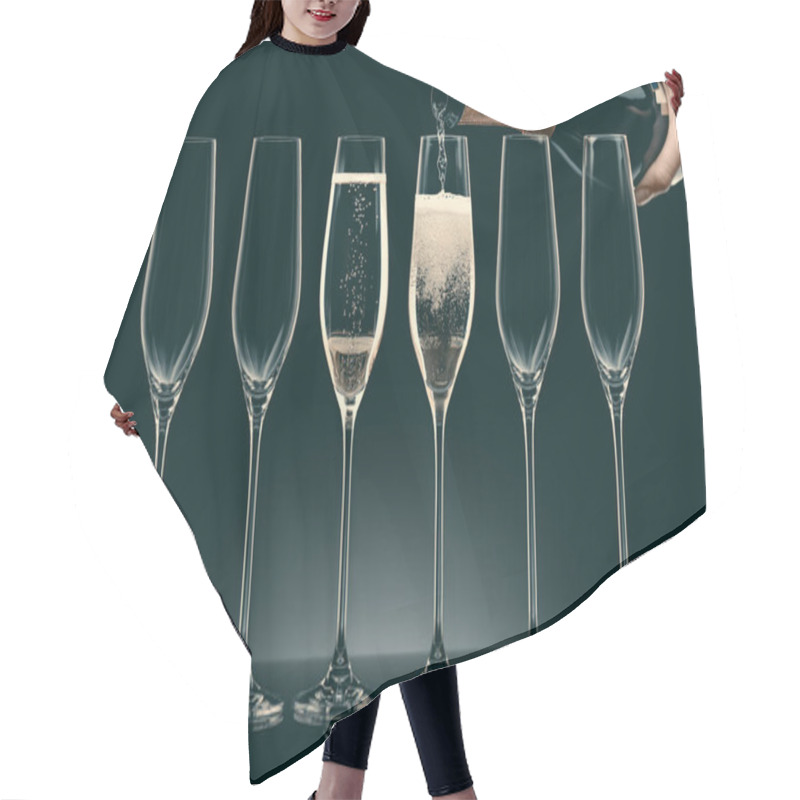 Personality  Cropped Image Of Woman Pouring Champagne From Bottle Into Six Transparent Glasses On Black Hair Cutting Cape