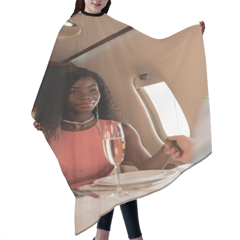 Personality  Cropped View Of Man Holding Hands With Elegant African American Woman In Private Plane Hair Cutting Cape