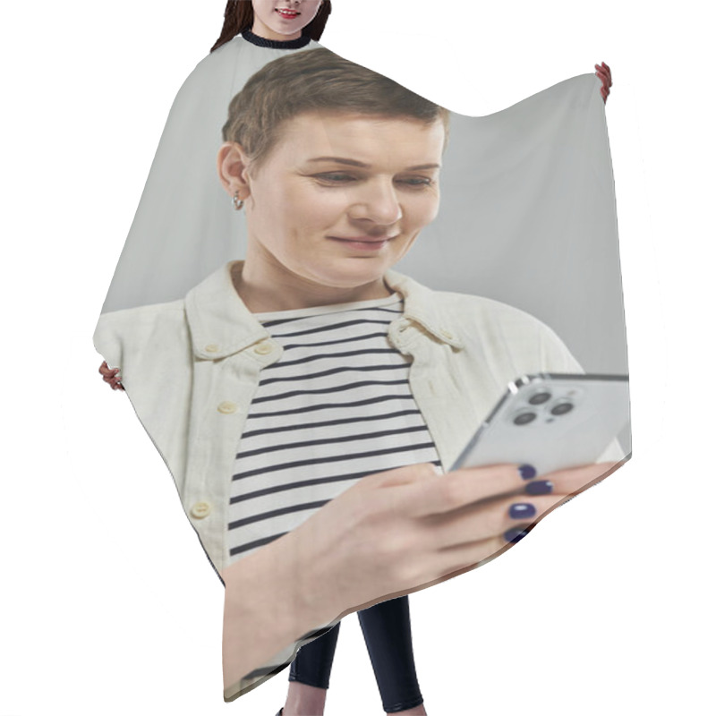 Personality  A Woman With Short Hair And A Casual Outfit Smiles As She Uses A Smartphone. Hair Cutting Cape