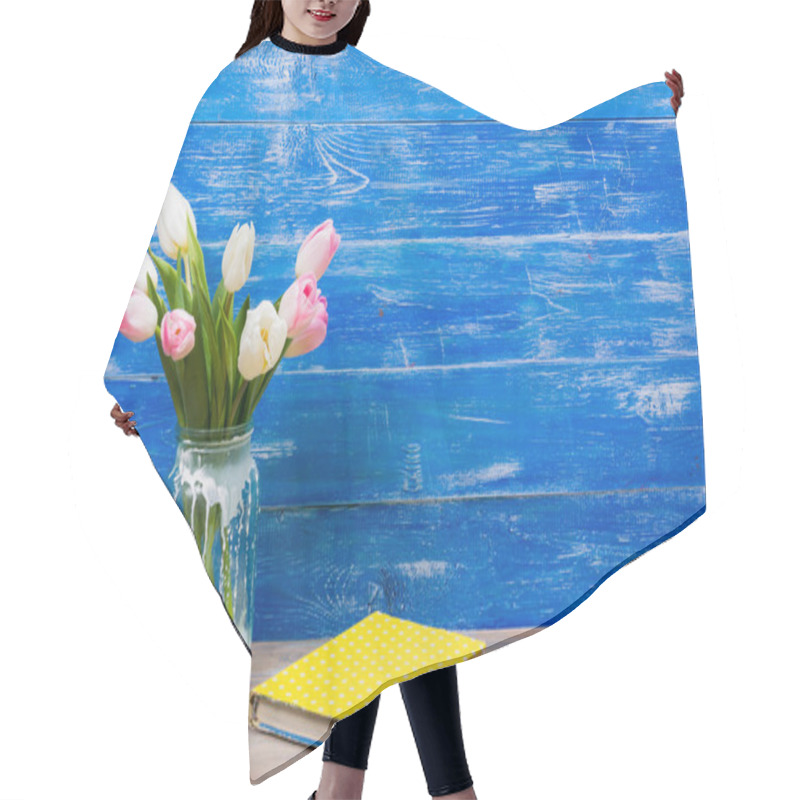 Personality  Colorful Tulips Flowers And Yellow Book On Blue Wooden Desk Table Background. Copy Space Hair Cutting Cape