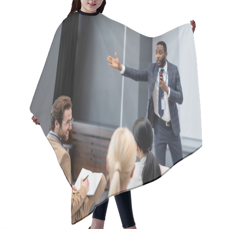 Personality  Smiling Businessman With Notebook Looking At Colleague Near Blurred African American Speaker In Conference Room  Hair Cutting Cape