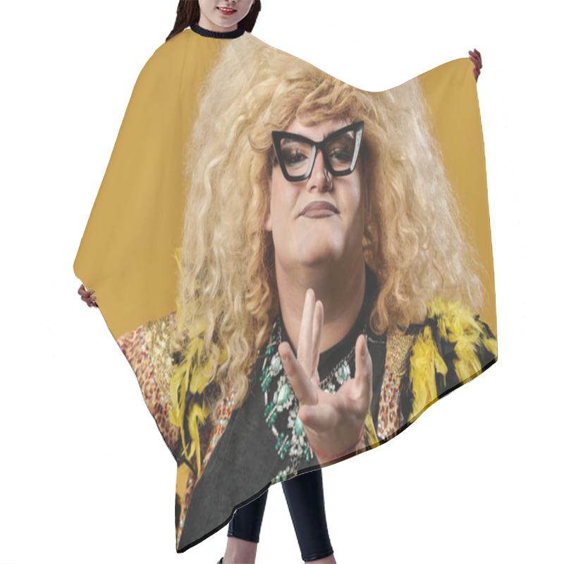 Personality  A Queer Person In A Glamorous Outfit Poses Against A Yellow Background. Hair Cutting Cape