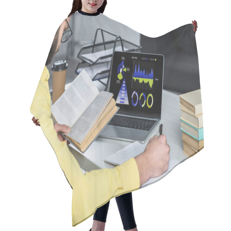 Personality  Bearded Man Studying With Book Near Laptop With Charts And Graphs On Screen In Modern Office Hair Cutting Cape