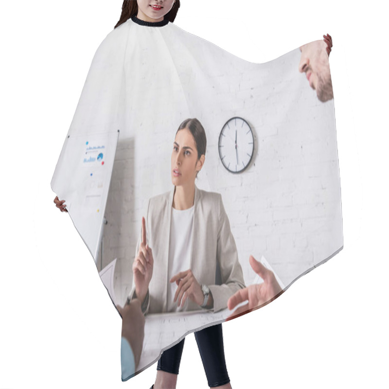 Personality  Serious Businesswoman Showing Attention Gesture During Meeting With Multicultural Business Partners Near Blueprint, Blurred Foreground Hair Cutting Cape