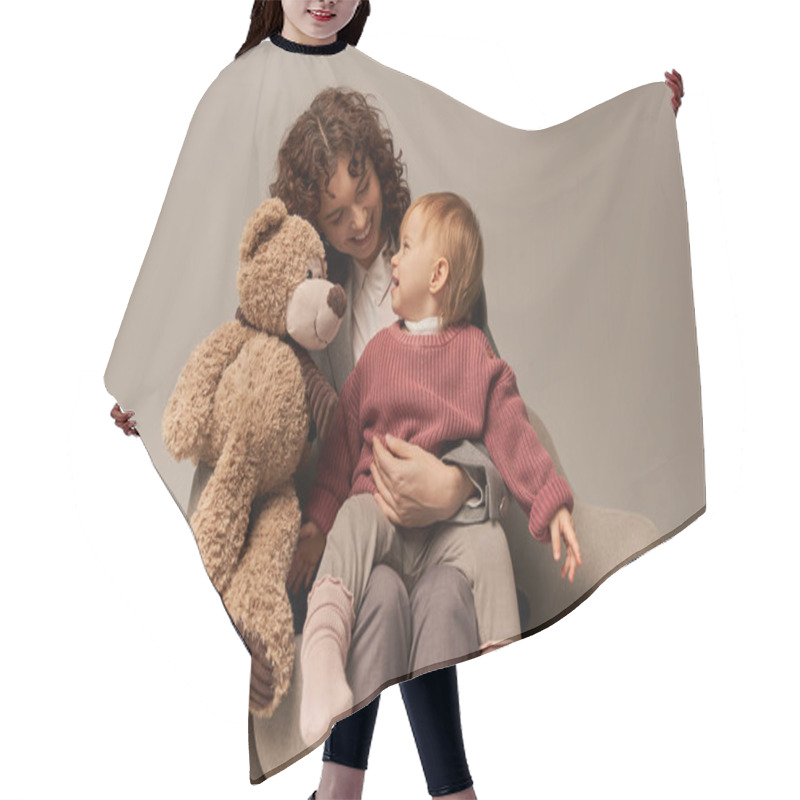 Personality  Quality Family Time, Parenting And Career, Happy Businesswoman Holding Teddy Bear Near Toddler Daughter On Grey Background, Sitting On Armchair, Work Life Harmony Concept, Working Parent  Hair Cutting Cape