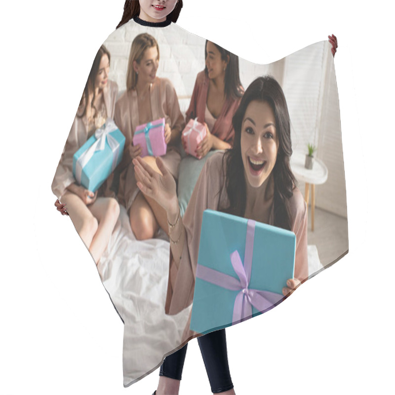 Personality  Selective Focus Of Excited Brunette Girl With Present Near Multiethnic Friends Holding Gift Boxes On Bed At Bachelorette Party Hair Cutting Cape