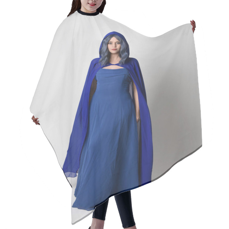 Personality  Full Length Portrait Of Beautiful Female Model Wearing Elegant Fantasy Blue Ball Gown And Flowing Cape With Hood.Standing Pose, With Gestural Arms Reaching Out . Isolated On White Studio Background. Hair Cutting Cape