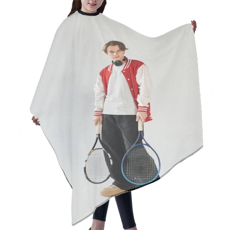 Personality  A Stylish Young Man In A Bomber Jacket Confidently Holds Tennis Rackets, Exuding Youth Culture. Hair Cutting Cape