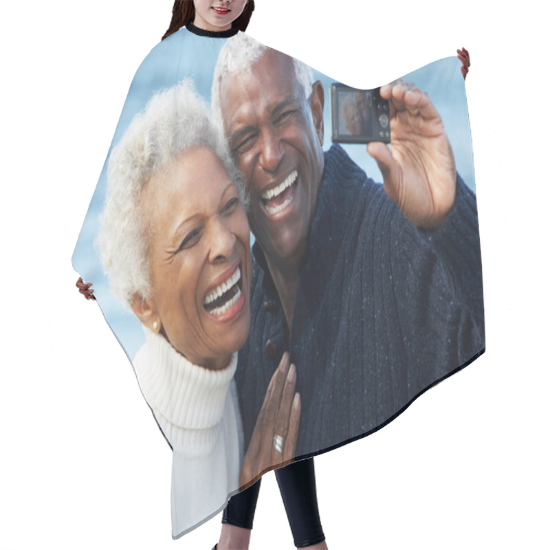 Personality  Senior Couple With Camera On Beach Hair Cutting Cape