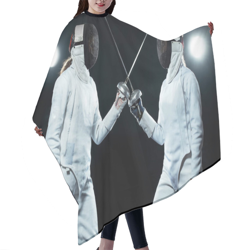 Personality  Young Fencer Athlete Wearing Mask And White Fencing Costume. Holding The Sword On Black Background With Lights. Hair Cutting Cape