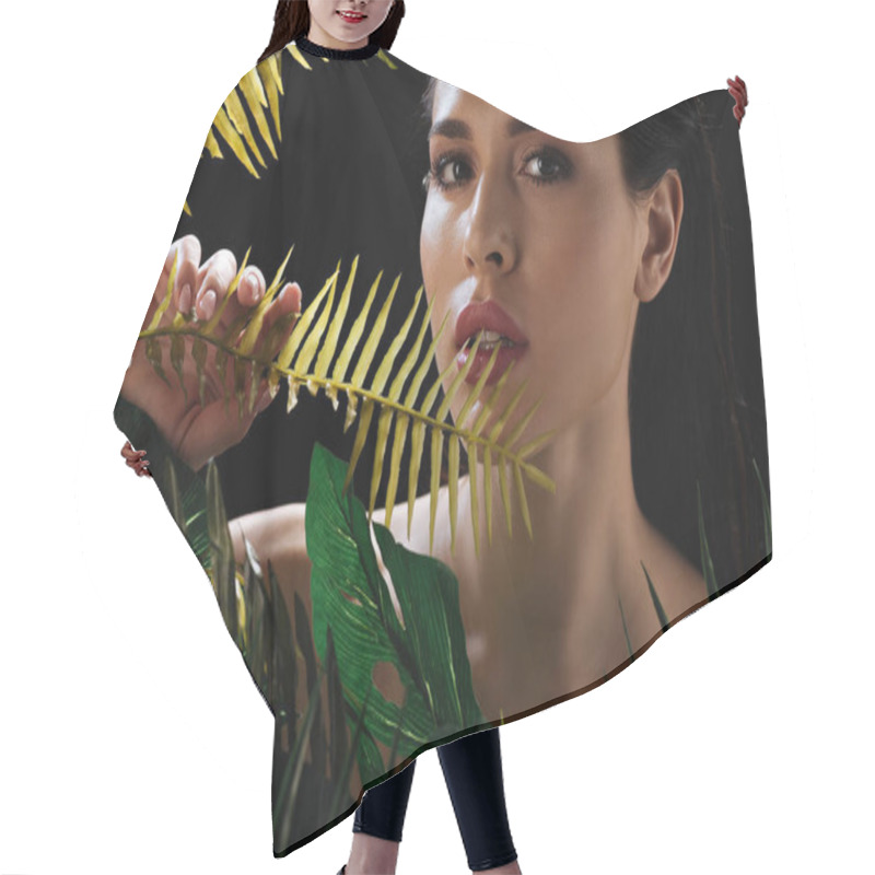 Personality  Portrait Of Sexy Woman Looking At Camera And Touching Leaf Isolated On Black Hair Cutting Cape