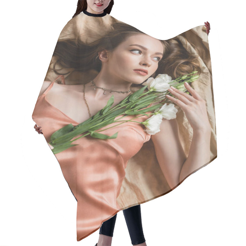 Personality  Top View Of Attractive Young Woman In Pink Silk Slip Dress Lying On Linen Fabric And Holding Delicate White Flowers On Beige Background, Sensuality, Elegance, Eustoma, Looking Away  Hair Cutting Cape