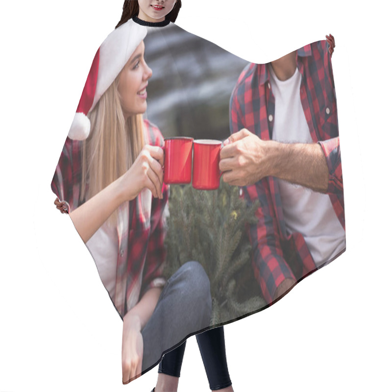 Personality  Smiling Couple Clinking With Red Cups While Sitting On Pickup Truck With Fir Tree For Christmas  Hair Cutting Cape