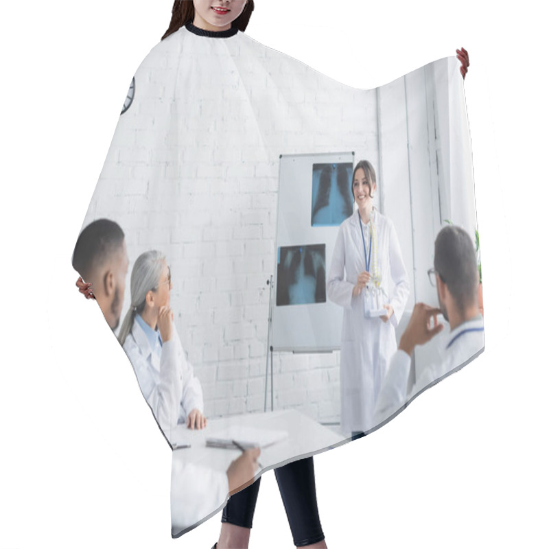 Personality  Smiling Doctor Standing Near Flip Chart With Lungs X-rays And Showing Spine Model To Multiethnic Colleagues  Hair Cutting Cape