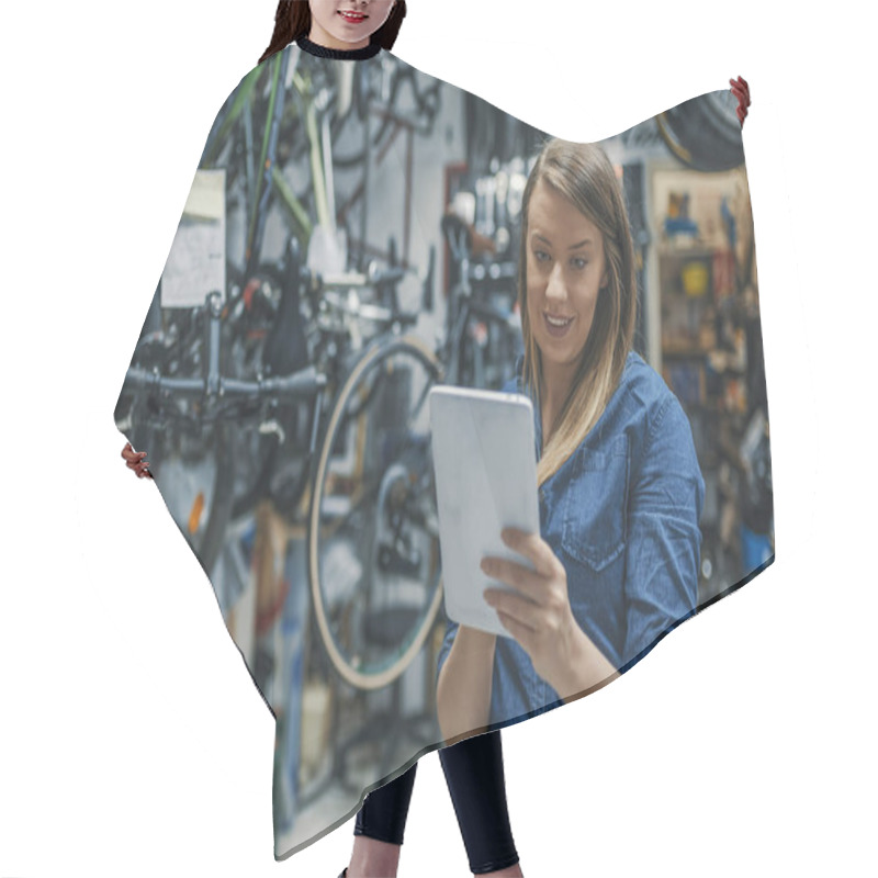 Personality  Female Mechanic At Work. Using A Tablet While Fixing A Bicycle. Female Bicycle Repair Technician Using Digital Tablet In Bicycle Shop. Verify The Checklist. Mechanic Woman Checking Something On A Tablet-pc And Checklist. Hair Cutting Cape