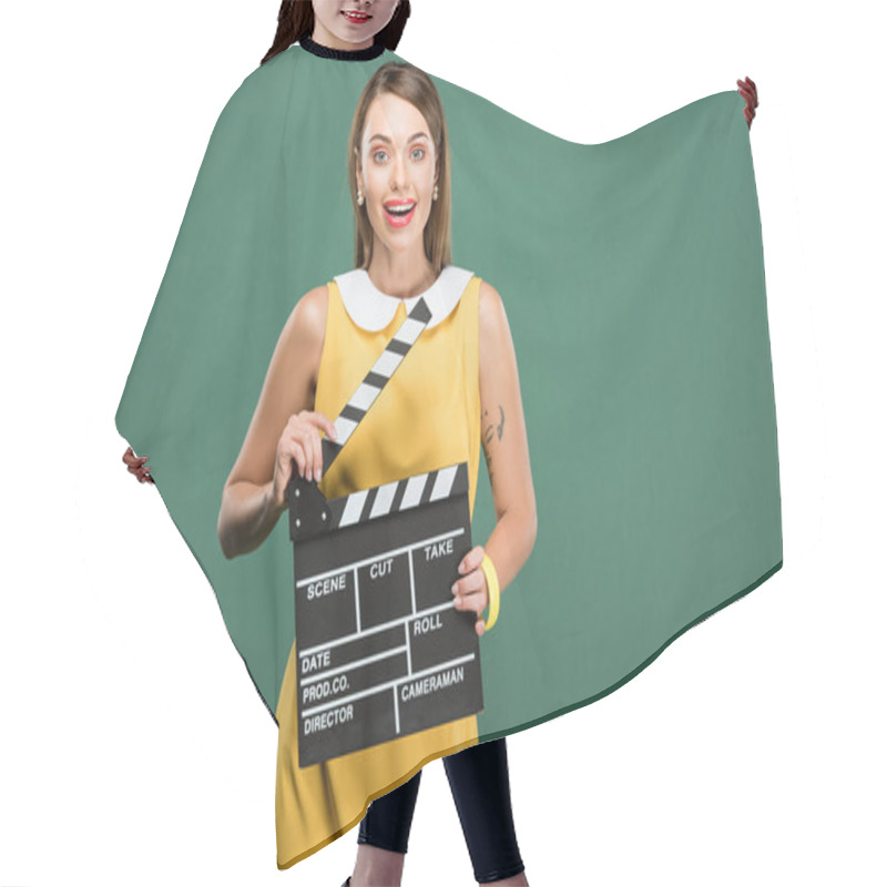 Personality  Beautiful Stylish Woman In Yellow Dress Looking At Camera And Holding Film Clapperboard Isolated On Green Hair Cutting Cape