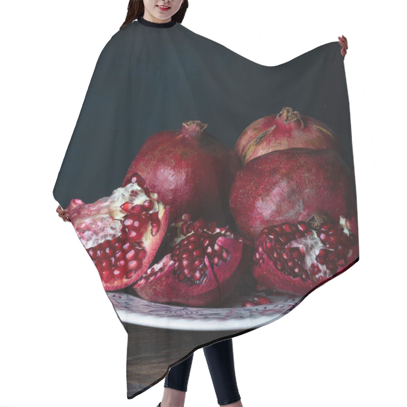 Personality   Ripe And Juicy Pomegranate Fruits Close-up On A Black Background. Hair Cutting Cape